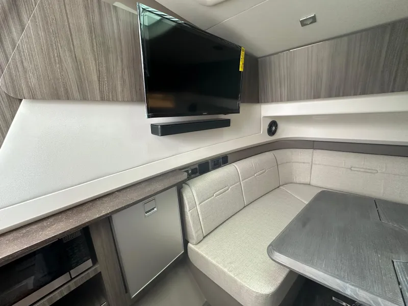 Slide: The Image of 2025 Sea Ray SLX 400 OB interior with TV, seating, and table. - 19