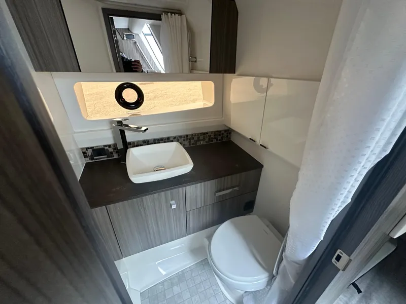 Slide: The Image of 2025 Sea Ray SLX 400 OB bathroom with modern sink, toilet, and sleek cabinetry. - 20
