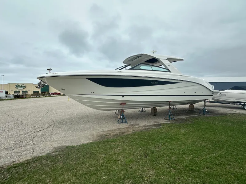 Slide: The Image of 2025 Sea Ray SLX 400 OB boat on stands, displayed outdoors on a cloudy day. - 5