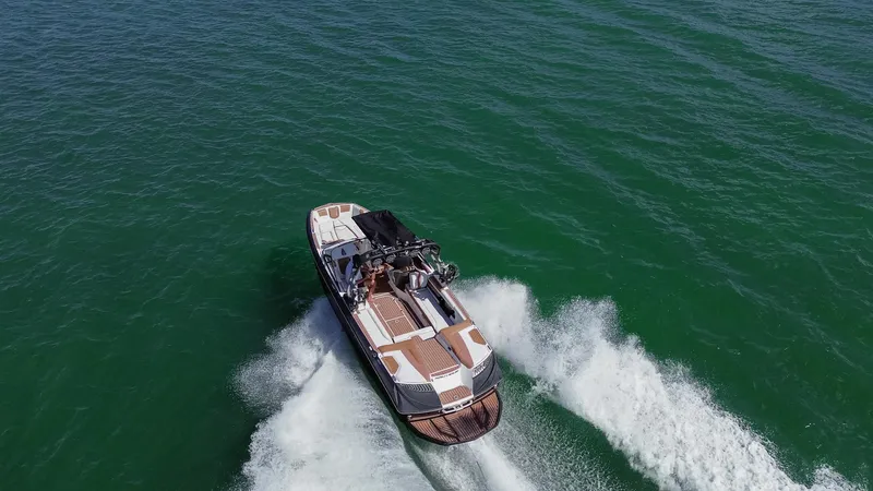 Slide: The Image of 2018 Nautique Super Air Nautique G25 cruising on open water, aerial view. - 0