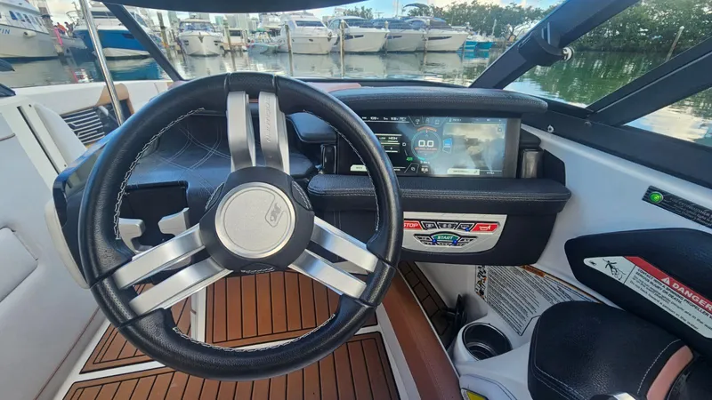 Slide: The Image of 2018 Nautique Super Air Nautique G25 dashboard with steering wheel and digital display. - 13