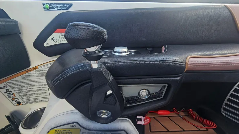 Slide: The Image of Interior of 2018 Nautique Super Air Nautique G25 boat, featuring control panel and gear lever. - 16