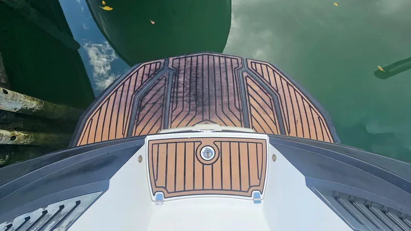 Slide: The Image of 2018 Nautique Super Air Nautique G25 swim platform, teak finish, docked on calm water. - 17