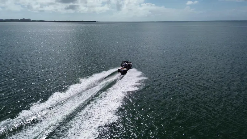 Slide: The Image of 2018 Nautique Super Air Nautique G25 cruising on open water under a clear sky. - 20