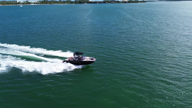 Slide: The Image of 2018 Nautique Super Air Nautique G25 speeding on open water, creating a dynamic wake. - 22