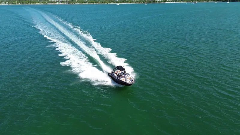 Slide: The Image of 2018 Nautique Super Air Nautique G25 speeding on open water, leaving a wake trail. - 24