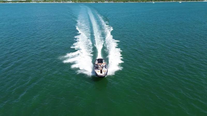Slide: The Image of 2018 Nautique Super Air Nautique G25 cruising on open water, leaving a wake trail. - 25