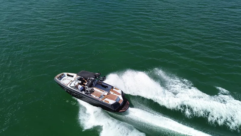 Slide: The Image of 2018 Nautique Super Air Nautique G25 cruising on open water, creating a dynamic wake. - 27