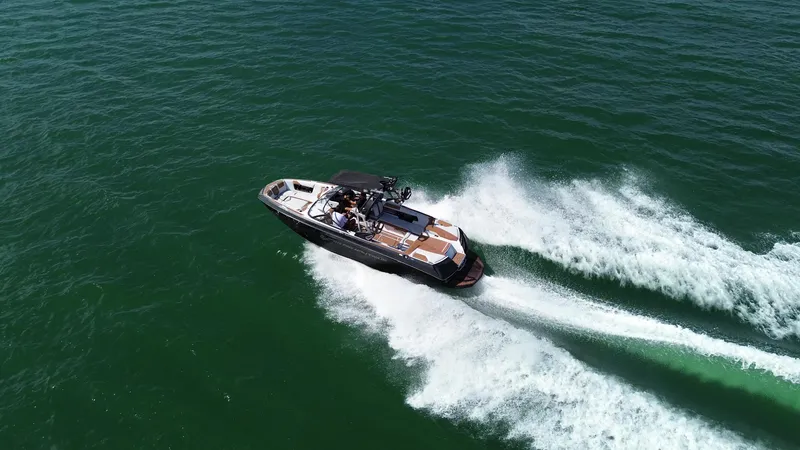 Slide: The Image of 2018 Nautique Super Air Nautique G25 speeding on open water, creating a dynamic wake. - 29