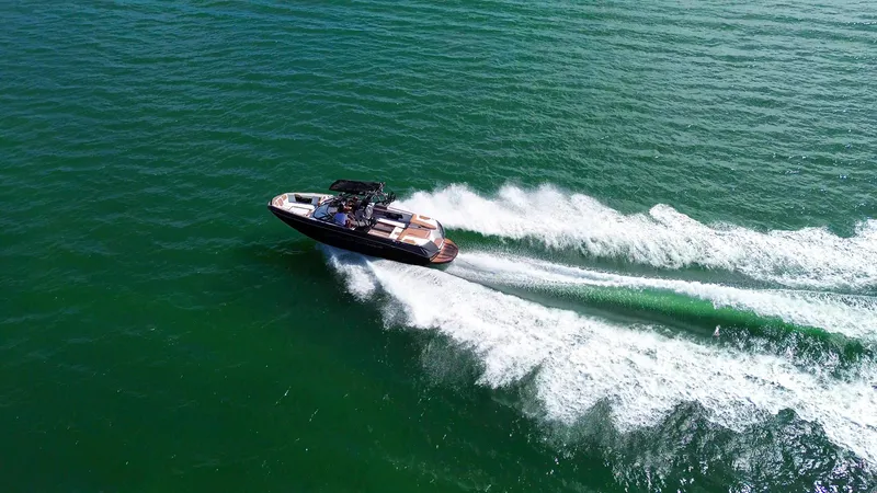 Slide: The Image of 2018 Nautique Super Air Nautique G25 speeding on open water, creating dynamic wake trails. - 30