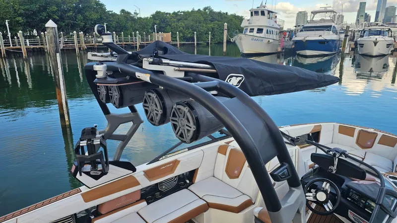 Slide: The Image of 2018 Nautique Super Air Nautique G25 boat with advanced sound system, docked in a marina. - 8