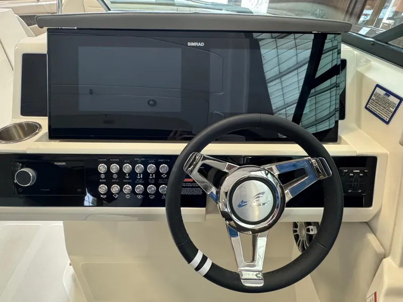 Slide: The Image of 2025 Sea Ray SLX 350 helm with modern steering wheel and control panel. - 15