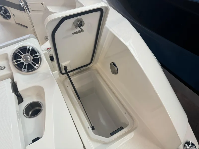 Slide: The Image of 2025 Sea Ray SLX 350 boat storage compartment with speaker and cup holder. - 5