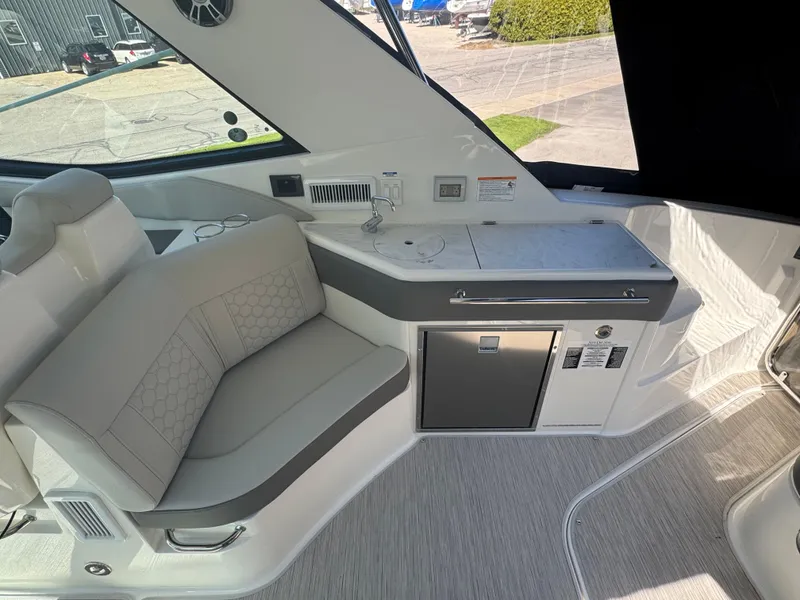 Slide: The Image of 2025 Sea Ray Sundancer 320 Coupe interior with seating and kitchenette area. - 15