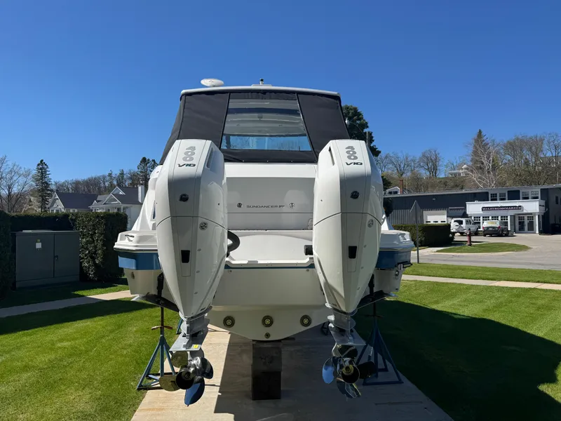 Slide: The Image of 2025 Sea Ray Sundancer 320 Coupe with dual outboard engines, displayed on a sunny day. - 2