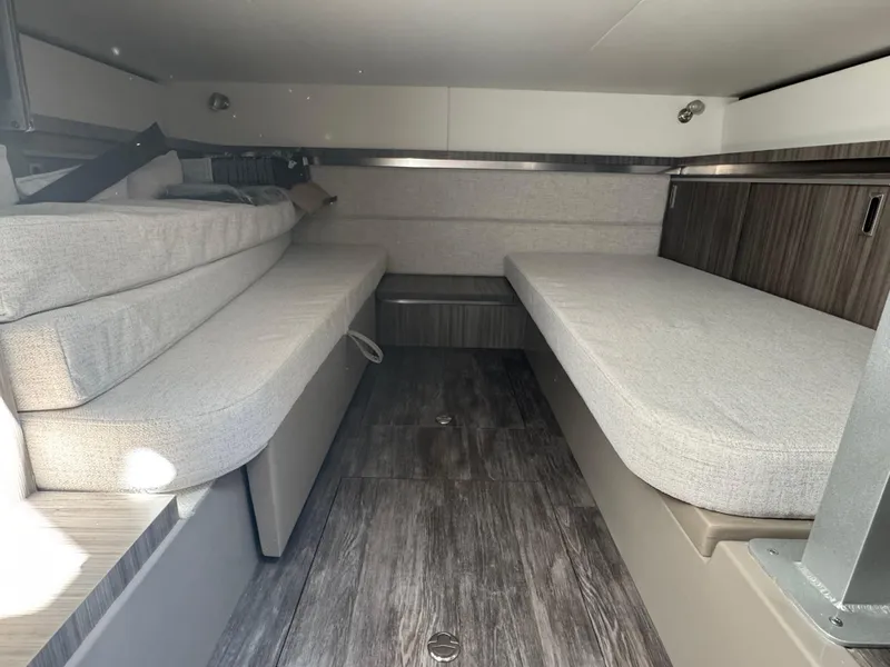 Slide: The Image of 2025 Sea Ray Sundancer 320 Coupe cabin interior with modern seating and wood flooring. - 24
