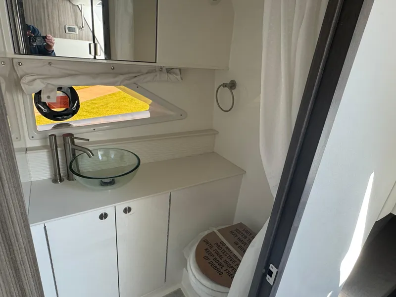 Slide: The Image of 2025 Sea Ray Sundancer 320 Coupe bathroom with modern sink and toilet. - 25