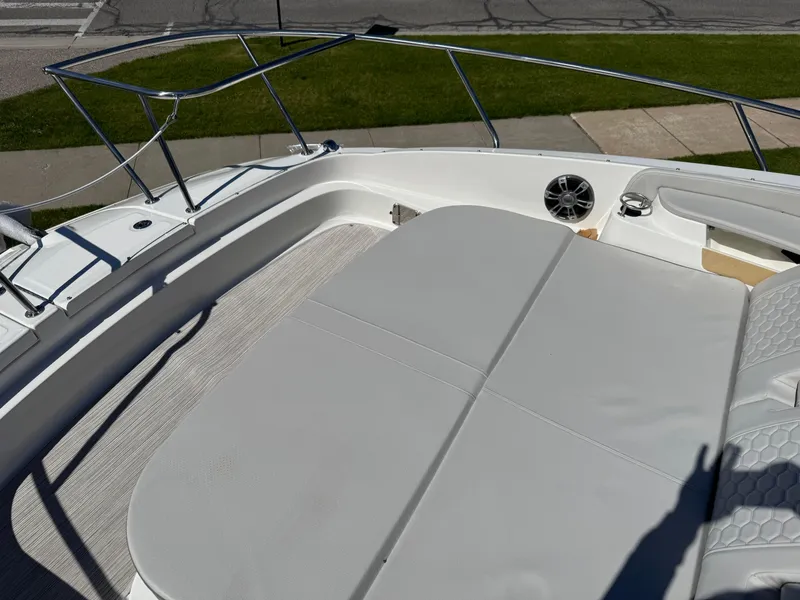 Slide: The Image of 2025 Sea Ray Sundancer 320 Coupe deck with cushioned seating and stainless steel railing. - 5