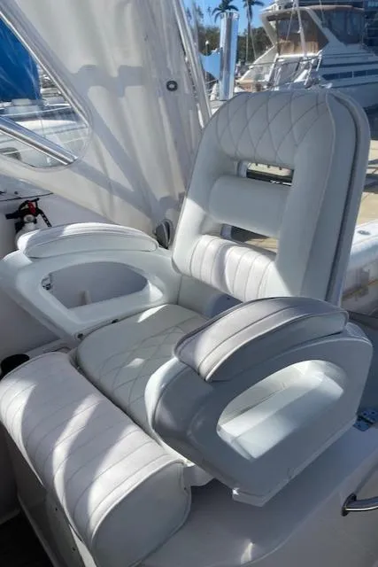 Slide: The Image of Luxurious white seating on a 2005 Pro-Line Express boat, docked at a marina. - 12