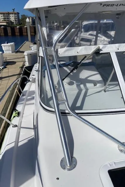 Slide: The Image of 2005 Pro-Line Express boat docked, showcasing sleek design and sturdy railings. - 18