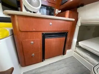 Slide: The Image of 2005 Pro-Line Express boat interior with wooden cabinetry and compact fan. - 22