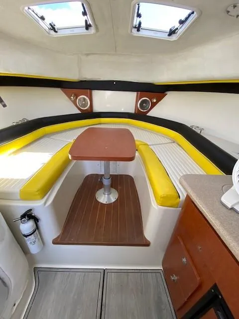 Slide: The Image of 2005 Pro-Line Express boat interior with yellow seating and wooden table. - 23