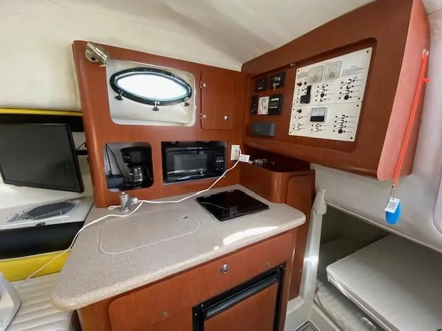 Slide: The Image of 2005 Pro-Line Express boat interior with kitchenette, microwave, and control panel. - 25