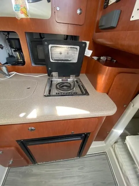 Slide: The Image of 2005 Pro-Line Express boat interior with compact kitchen and stove. - 26