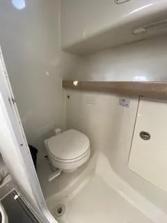 Slide: The Image of 2005 Pro-Line Express boat bathroom interior with toilet and storage. - 28