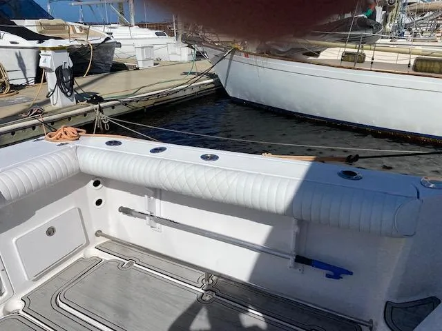 Slide: The Image of 2005 Pro-Line Express boat interior at marina, featuring white seating and fishing rod holders. - 8