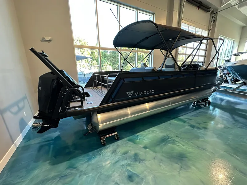 Slide: The Image of 2025 Viaggio Lago X-S pontoon boat in showroom, sleek black design. - 1
