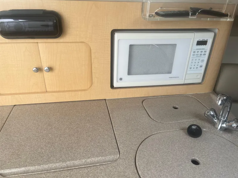 Slide: The Image of 2002 Boston Whaler 295 Conquest WA interior kitchen with microwave and sink. - 37