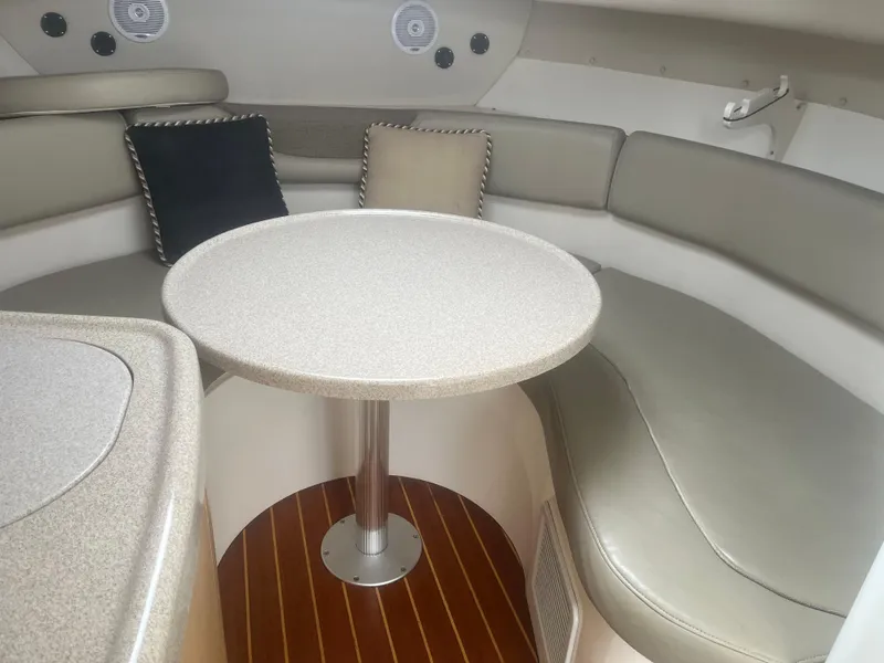 Slide: The Image of Interior of 2002 Boston Whaler 295 Conquest WA with cushioned seating and round table. - 40