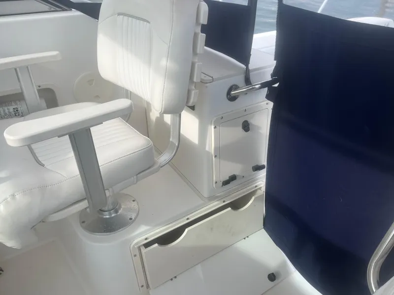Slide: The Image of Interior of 2002 Boston Whaler 295 Conquest WA with white seating and storage compartments. - 48