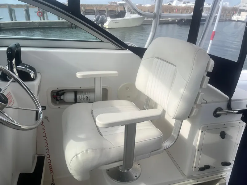 Slide: The Image of Boston Whaler 295 Conquest WA 2002 helm seat with steering wheel and fire extinguisher. - 49