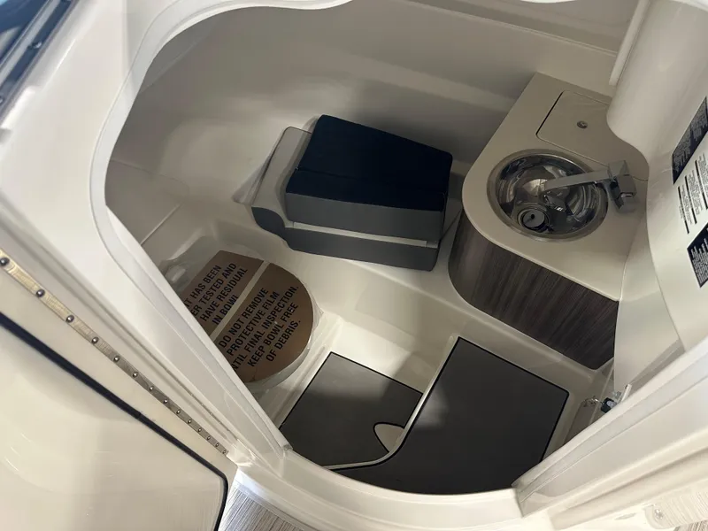 Slide: The Image of 2025 Sea Ray SDX 250 boat interior with compact bathroom and sink. - 15