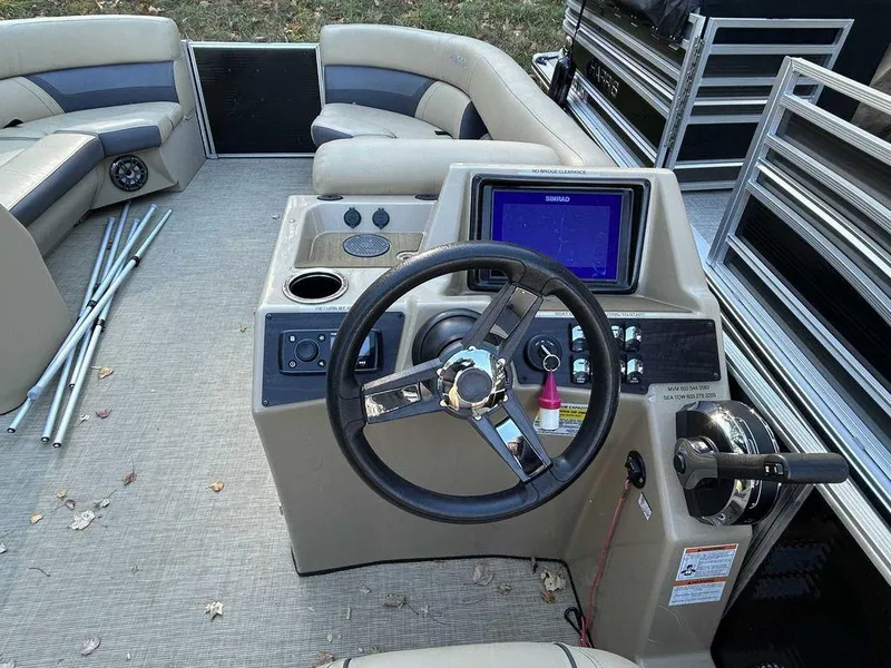 Slide: The Image of 2021 Harris Cruiser 250 boat interior with steering console and seating. - 12