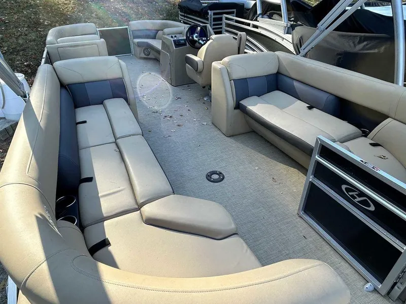 Slide: The Image of 2021 Harris Cruiser 250 pontoon boat interior with beige seating and steering console. - 13