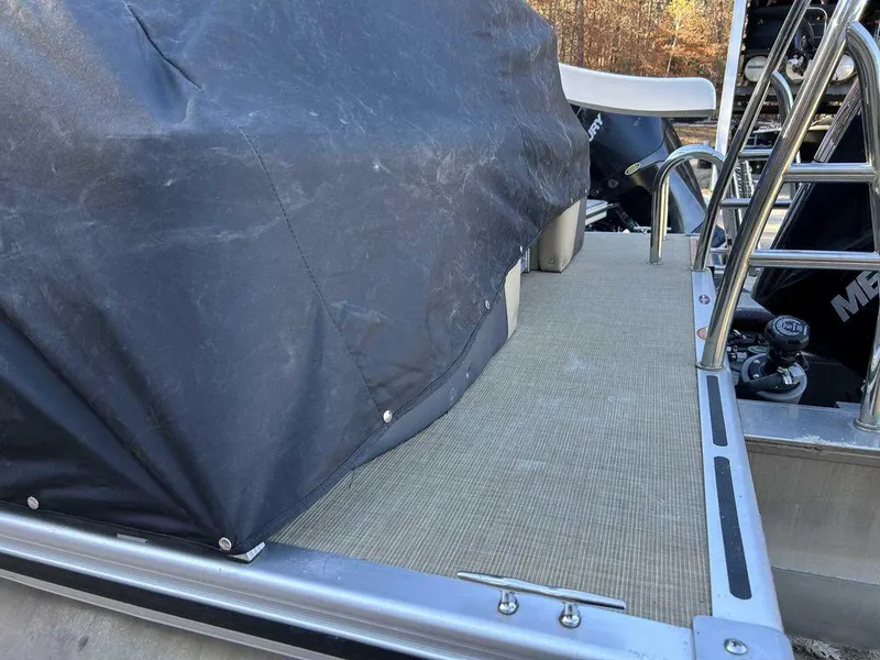 Slide: The Image of 2021 Harris Cruiser 250 pontoon boat with cover and ladder, outdoor setting. - 3