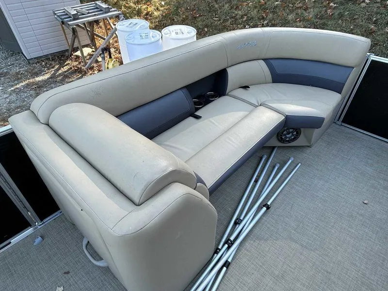 Slide: The Image of 2021 Harris Cruiser 250 boat interior with beige seating and metal poles. - 8