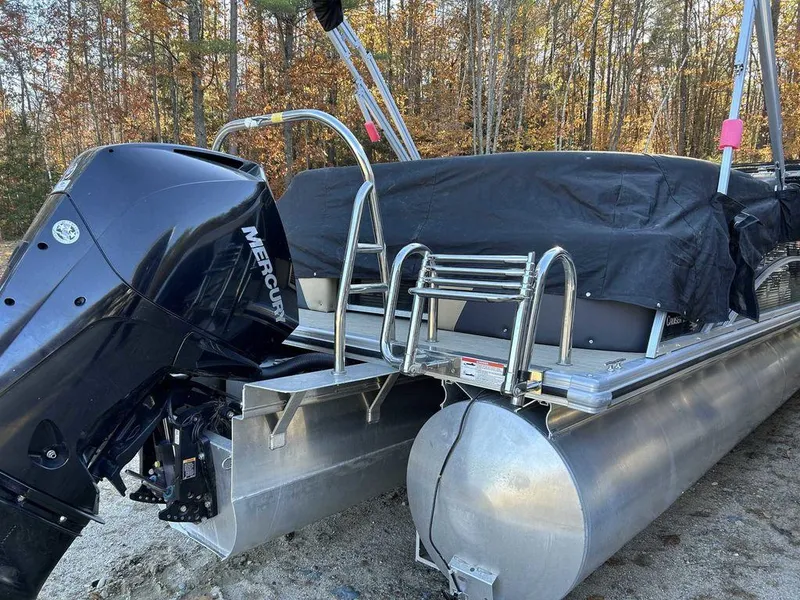 Slide: The Image of 2021 Harris Cruiser 250 pontoon boat with Mercury engine, covered and parked outdoors. - 9