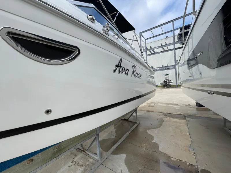 Slide: The Image of 2013 Cobalt 24SD boat on stands, side view, with "Ava Rose" name visible. - 10