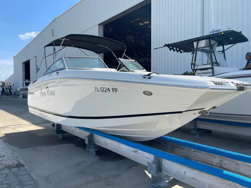 Slide: The Image of 2013 Cobalt 24SD boat on display outside a large warehouse. - 2