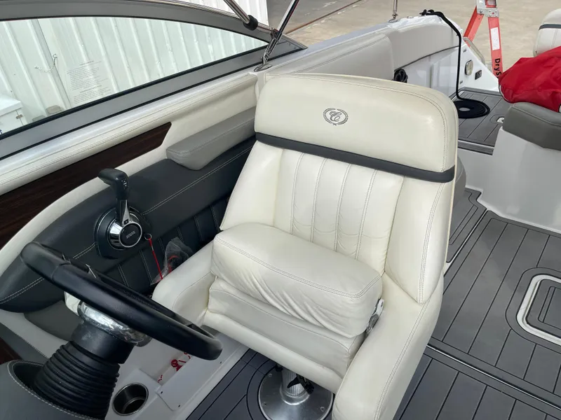 Slide: The Image of 2013 Cobalt 24SD boat interior with white captain's seat and steering wheel. - 25