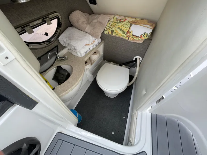 Slide: The Image of 2013 Cobalt 24SD boat bathroom with toilet, sink, and towels. - 29