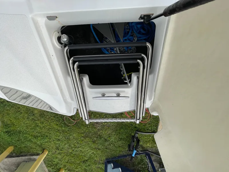 Slide: The Image of 2013 Cobalt 24SD boat ladder storage compartment with metal steps. - 36
