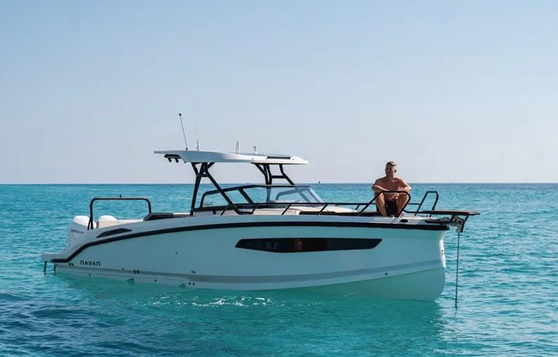 Slide: The Image of Navan S30 boat on clear blue water, 2025 model, with person relaxing on deck. - 12