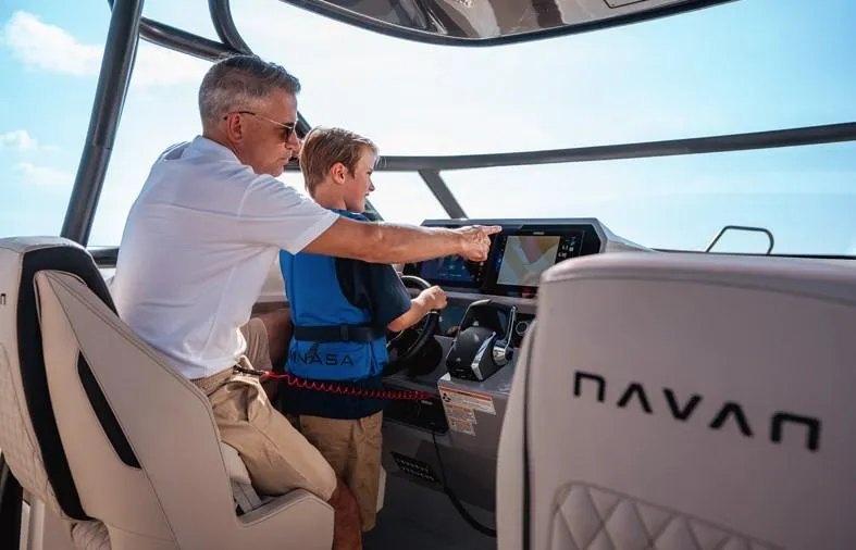 Slide: The Image of Man and child navigating on a 2025 Navan S30 boat, using advanced controls. - 8