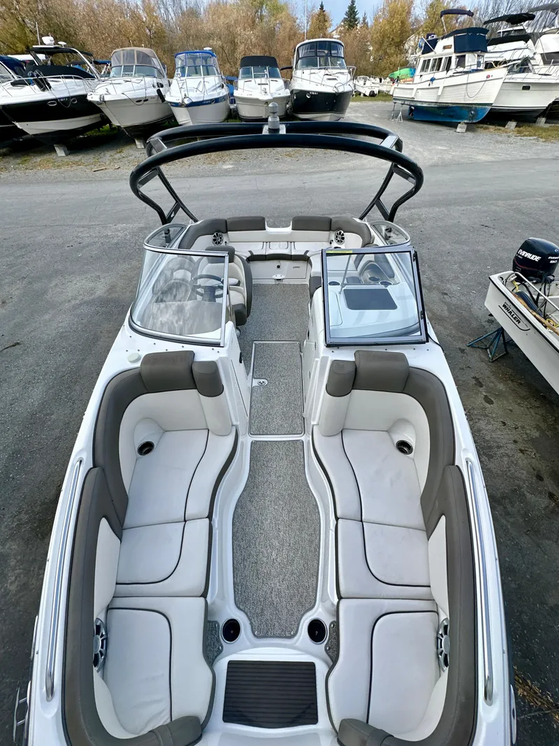Slide: The Image of 2012 Yamaha Boats 242 Limited S with spacious seating, docked among other boats. - 13