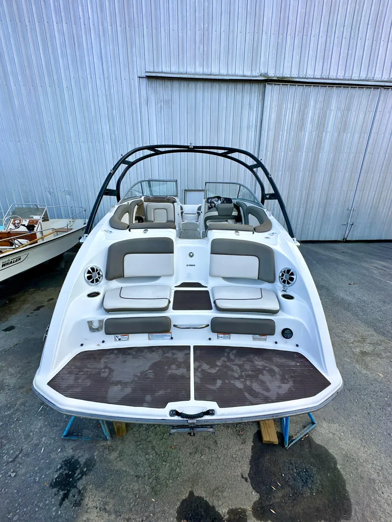 Slide: The Image of 2012 Yamaha Boats 242 Limited S, rear view, white and gray interior, docked outdoors. - 3